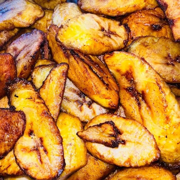 Close-up of golden-brown fried plantains, some with caramelized edges, from 876 Jerk.